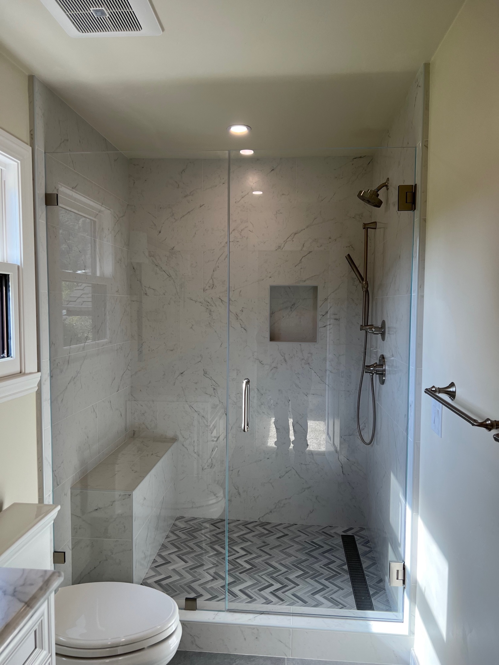 Carmel Valley master bath shower with frameless glass and floating marble bench