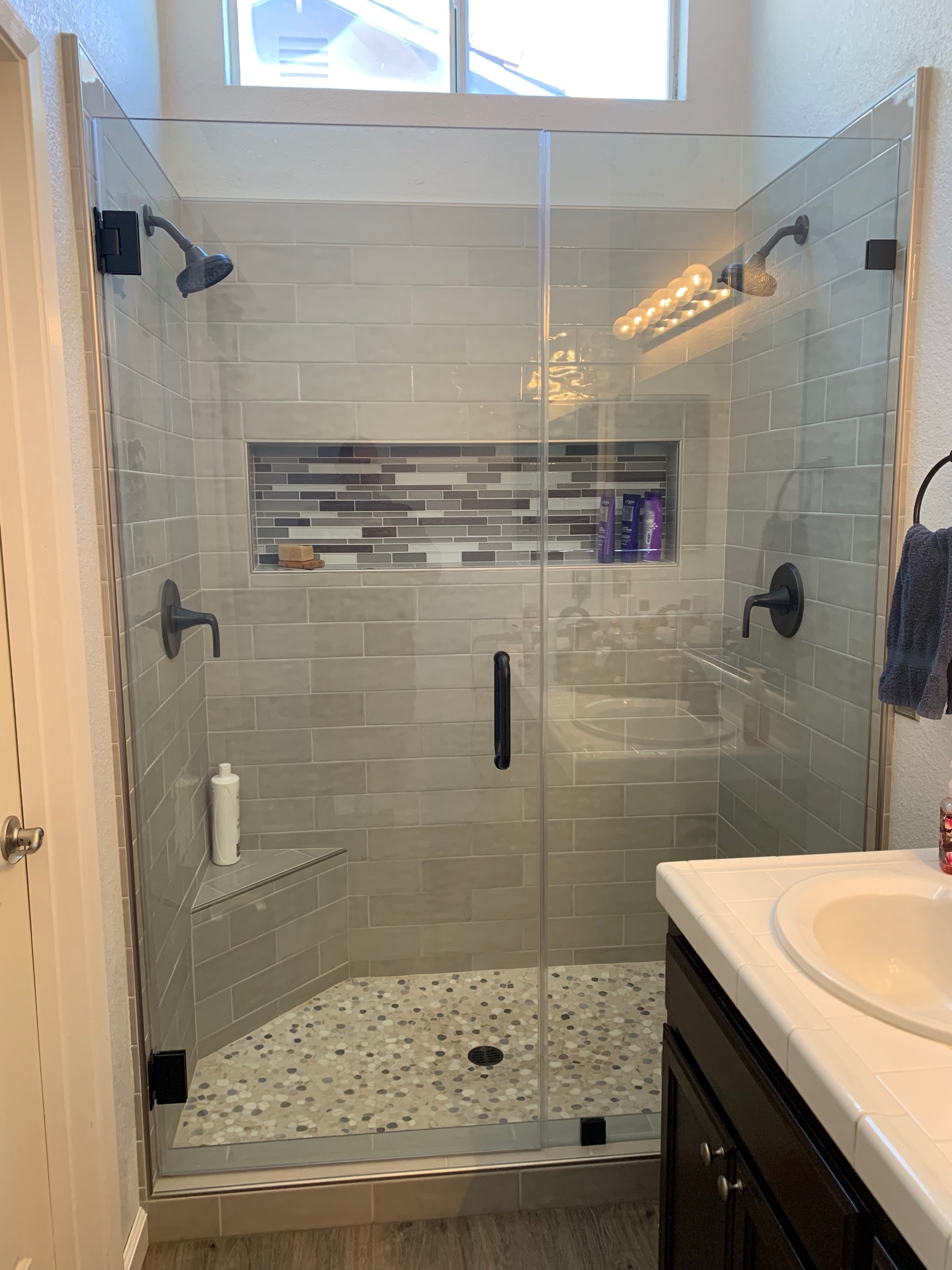 Hollister bathroom with frameless walk-in shower and pebble tile floor