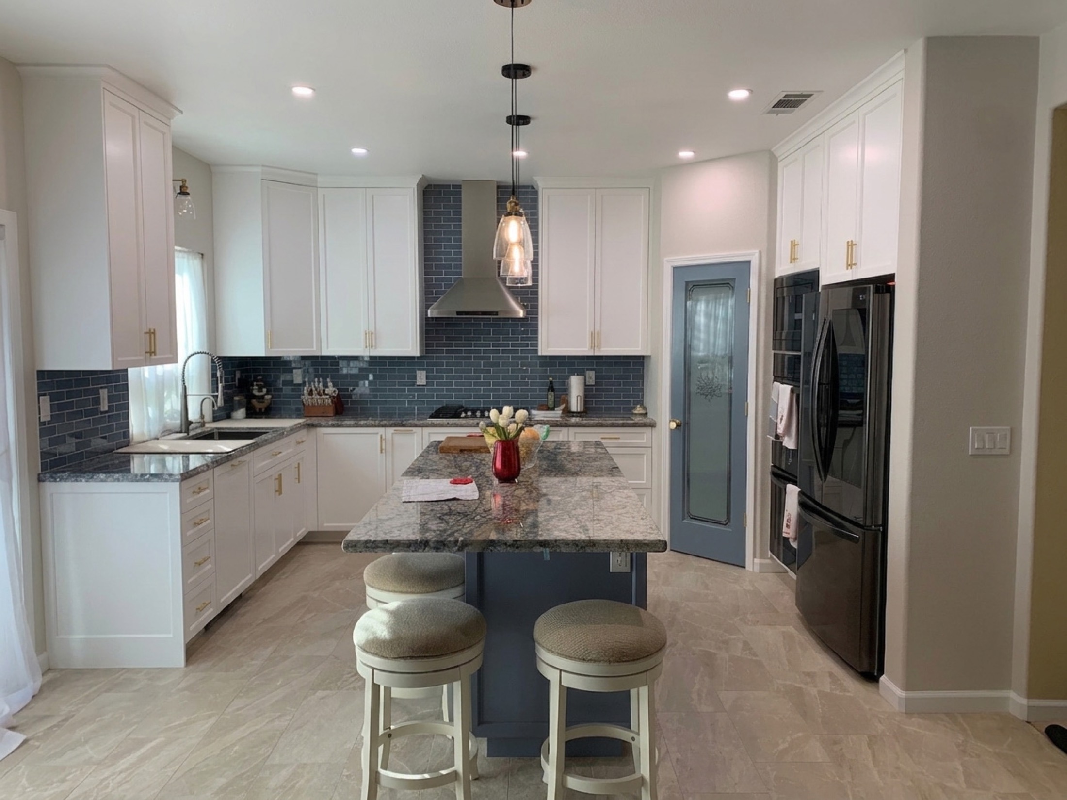 Hollister kitchen remodel featuring blue subway tile backsplash and navy island